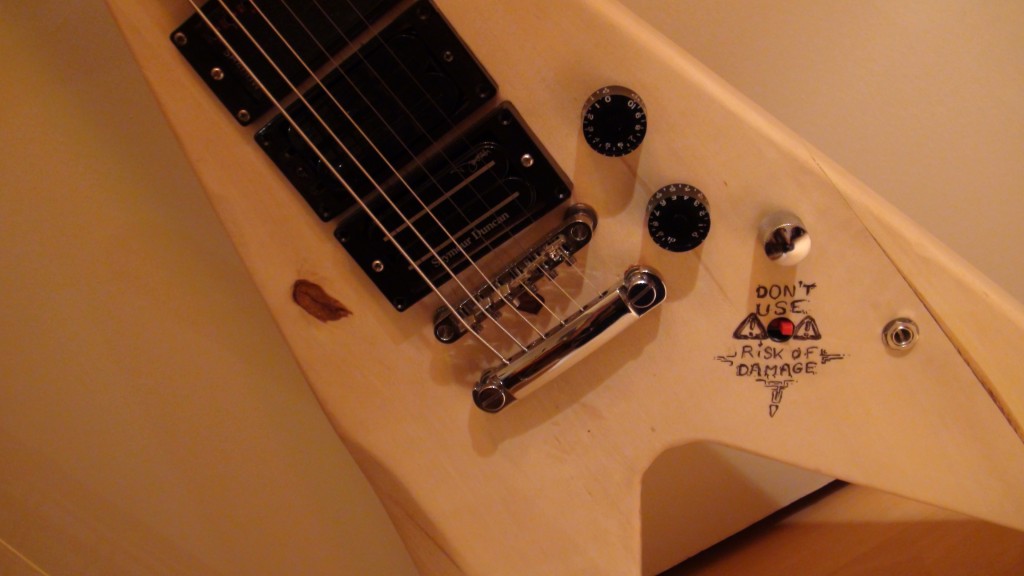 photo du bouton qui allume le préampli de la guitare, avec écris : ne pas utiliser, peut causer des dégâts.